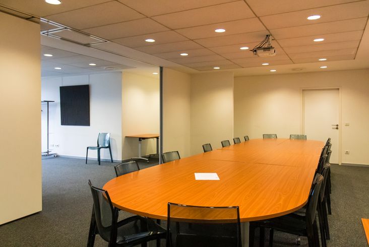 Table de réunion ovale entourée de chaises dans la salle de réunion